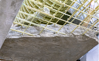 Concrete slab reinforced with a grid of yellow composite rebar, demonstrating fiberglass fabrication applications.