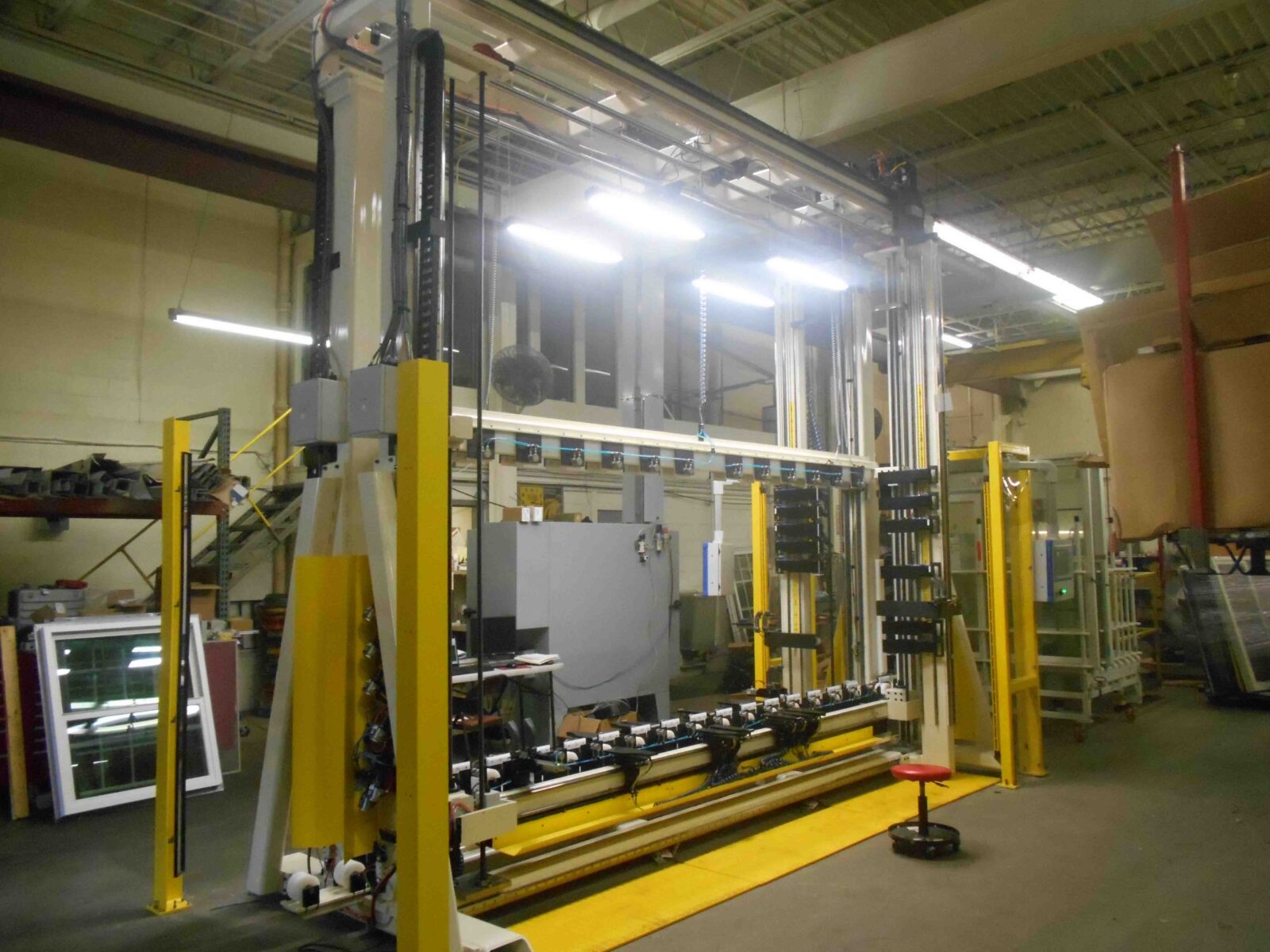 Large industrial SDL grille placement machine with heavy-duty frame, yellow safety posts, and bottom roller bed.
